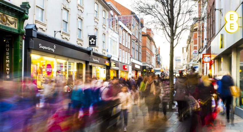 Shoppers hurry past in post-Christmas sales frenzy 2013. View along Clumber Street (toward Victoria Shopping Centre), Nottingham, England. 28th Dec 2013, busy post-Christmas sales. Captured with a long shutter speed to produce creative blur, and render faces blurred.